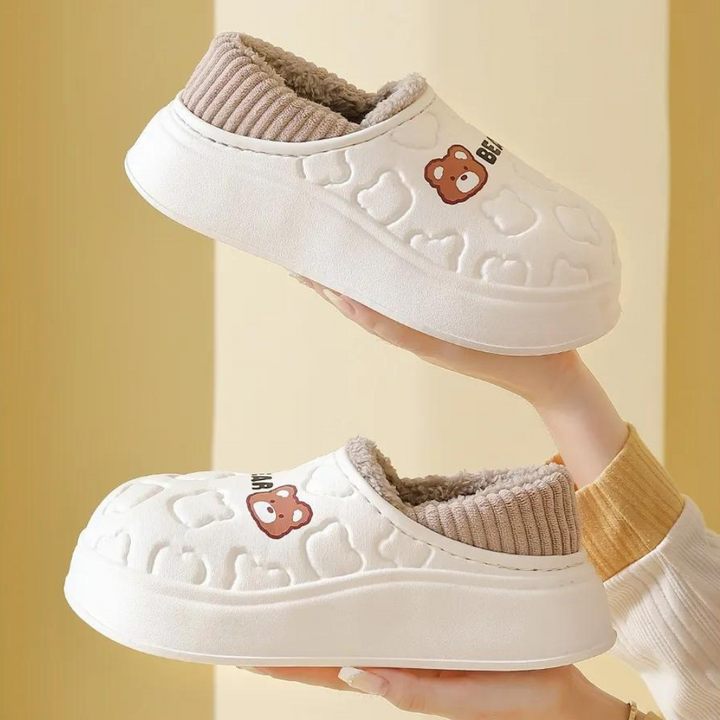 Witte pluche pantoffels met berenprint, dikke zool en geribbelde voering. Comfortabele winterhuispantoffels voor dames en heren.