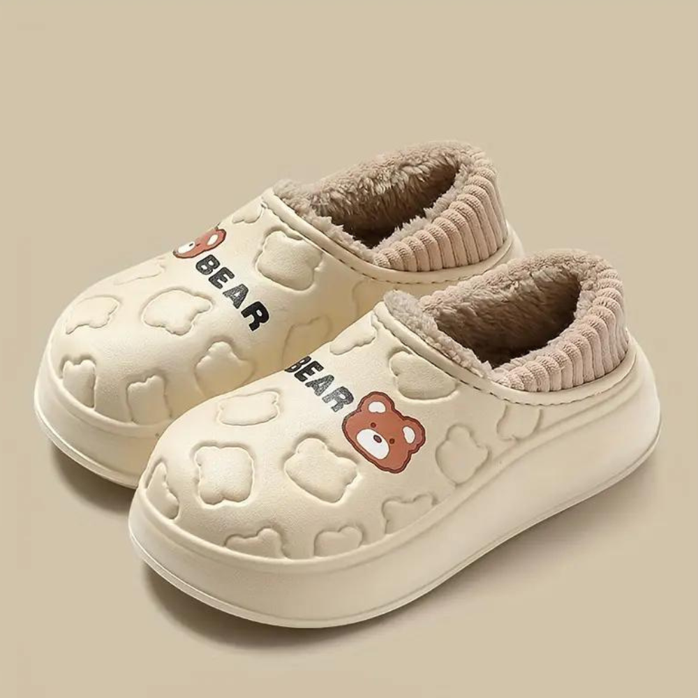 Crèmekleurige kinderpantoffels met berenmotief, pluche voering en antislipzool. Perfect voor warme voeten in de winter. Comfortabele en schattige sloffen.