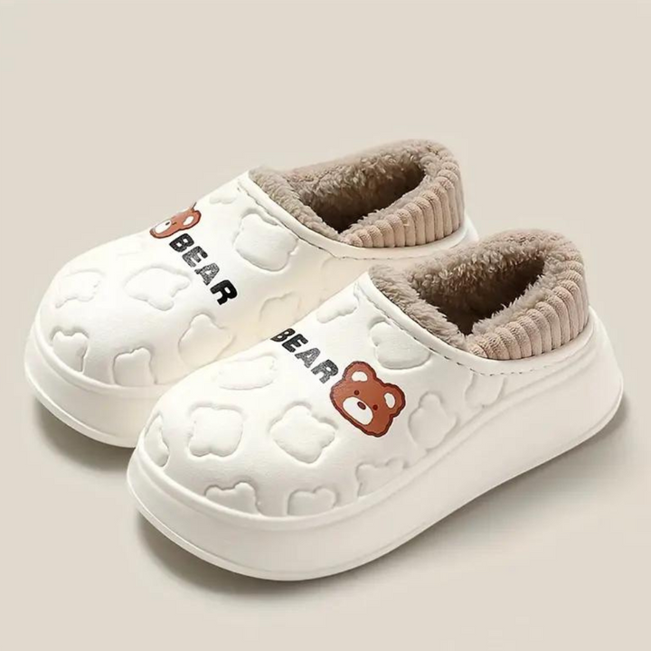 Witte kindersloffen met berenmotief, pluche voering en antislipzool. Perfect voor binnen, comfortabel en warm. Ideaal voor peuters en kleuters.