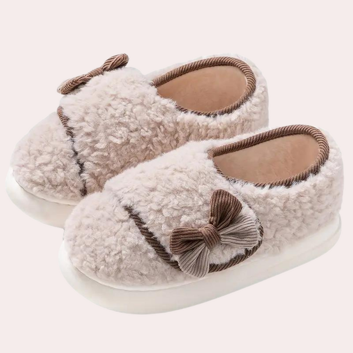 Lichtbruine, pluche babyslofjes met strikjes, ideaal voor comfort en warmte. Perfecte keuze voor babykleding en winteraccessoires.