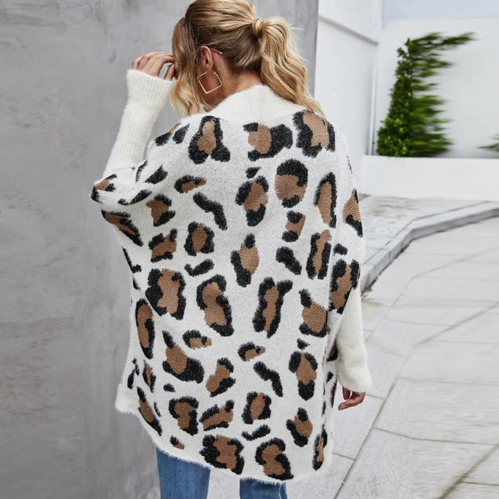 Vrouw in witte trui met luipaardprint, staand op straat. Modieuze dameskleding, herfststijl, casual outfit, trendy design.