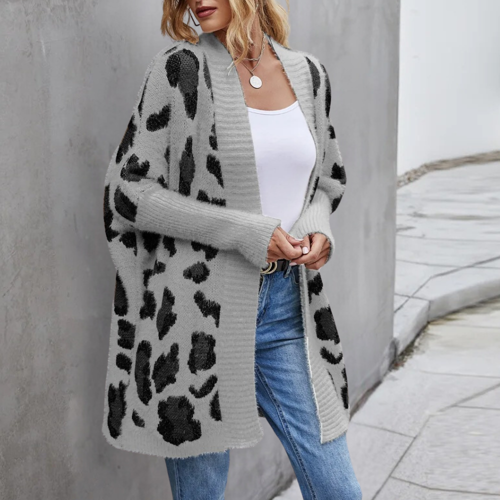 Grijze damesvest met luipaardprint, open voorkant, lange mouwen, casual stijl, perfect voor herfstmode, gecombineerd met witte top en jeans.