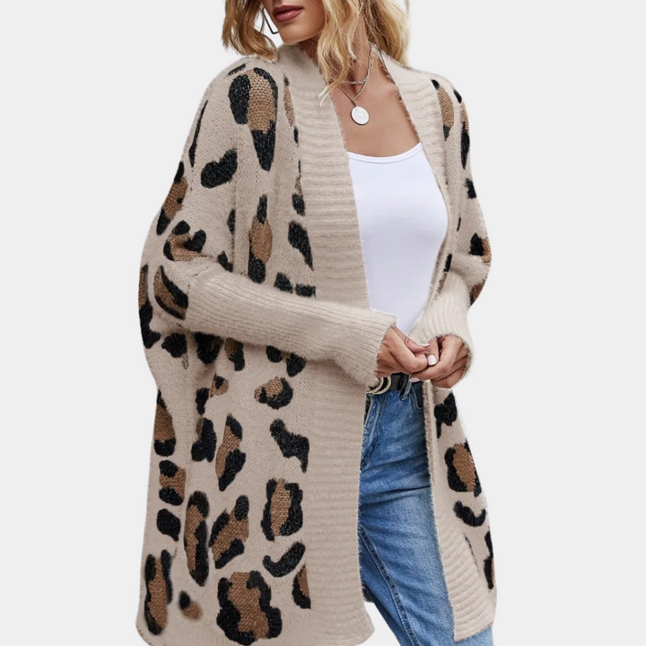 Vrouw draagt beige luipaardprint vest, witte top en blauwe jeans. Modieuze dameskleding, herfststijl, casual outfit.