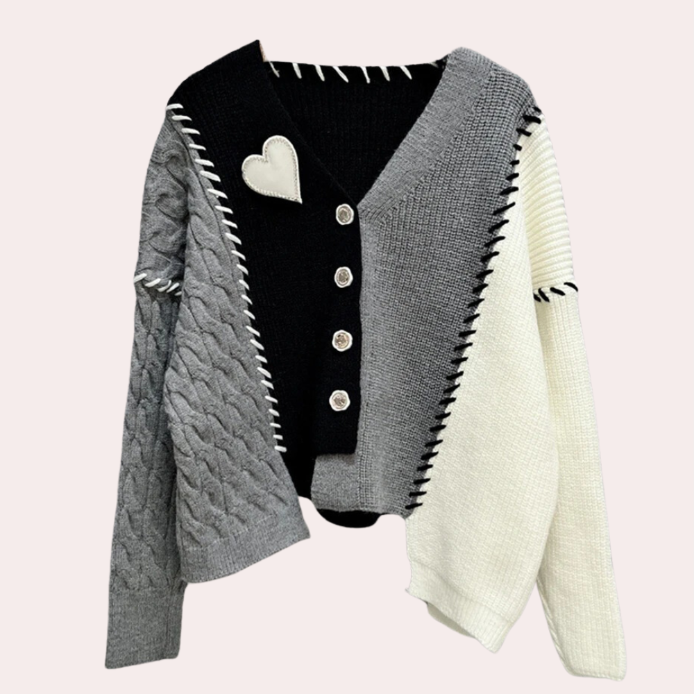 Zwart-grijs-witte gebreide trui met hartdetail, knopen en asymmetrisch ontwerp. Modieuze dameskleding, herfst-winter stijl.