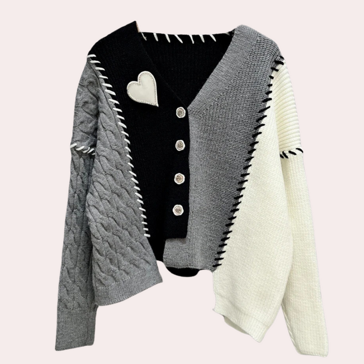 Zwart-grijs-witte gebreide trui met hartdetail, knopen en asymmetrisch ontwerp. Modieuze dameskleding, herfst-winter stijl.