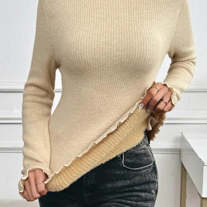 Beige geribbelde trui met ruches, gedragen door model. Perfect voor herfstmode. Combineer met jeans voor een casual, stijlvolle look.