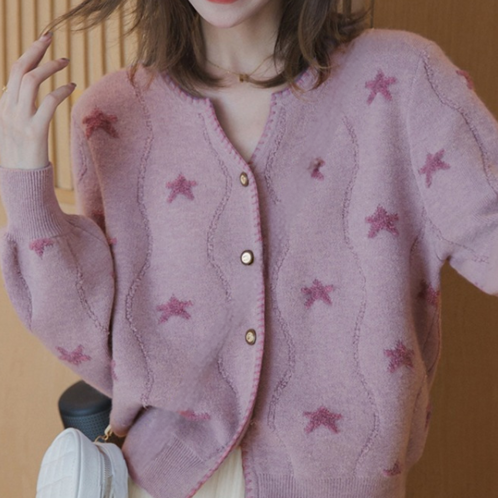 Roze damesvest met sterrenpatroon, lange mouwen en knoopsluiting. Modieuze gebreide trui, ideaal voor casual en stijlvolle outfits.