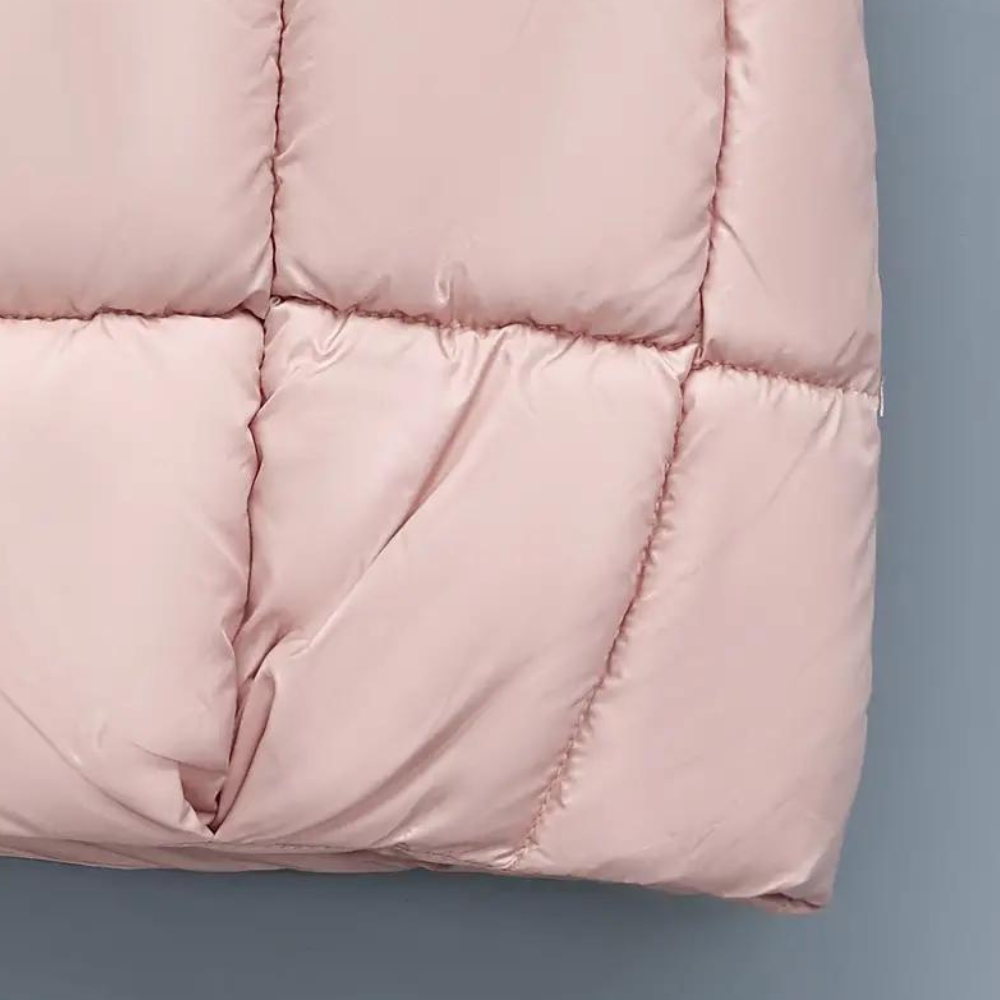 Roze gewatteerde jas detail, close-up van stof en stiksels. Modieuze winterjas, warme kleding, trendy damesmode, hoogwaardige materialen.