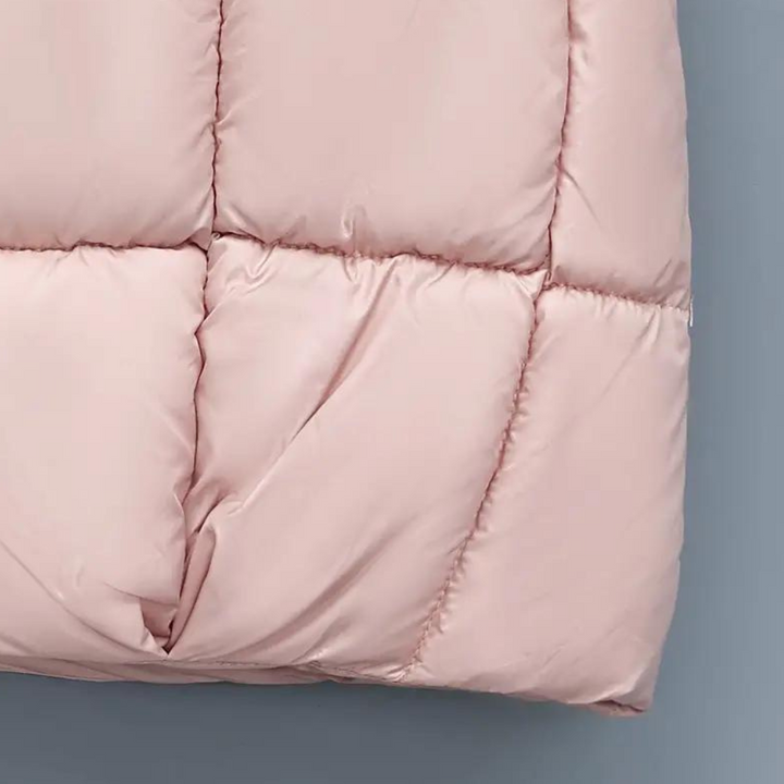 Roze gewatteerde jas detail, close-up van stof en stiksels. Modieuze winterjas, warme kleding, trendy damesmode, hoogwaardige materialen.