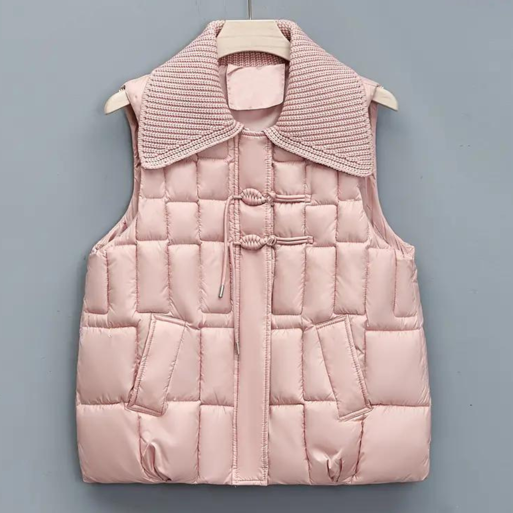 Roze gewatteerd dames bodywarmer met geribbelde kraag, knoopsluiting en zakken. Modieuze winterkleding, comfortabel en stijlvol.