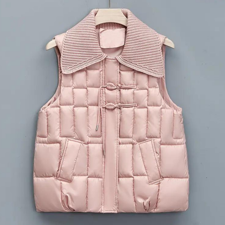 Roze gewatteerd dames bodywarmer met geribbelde kraag, knoopsluiting en zakken. Modieuze winterkleding, comfortabel en stijlvol.