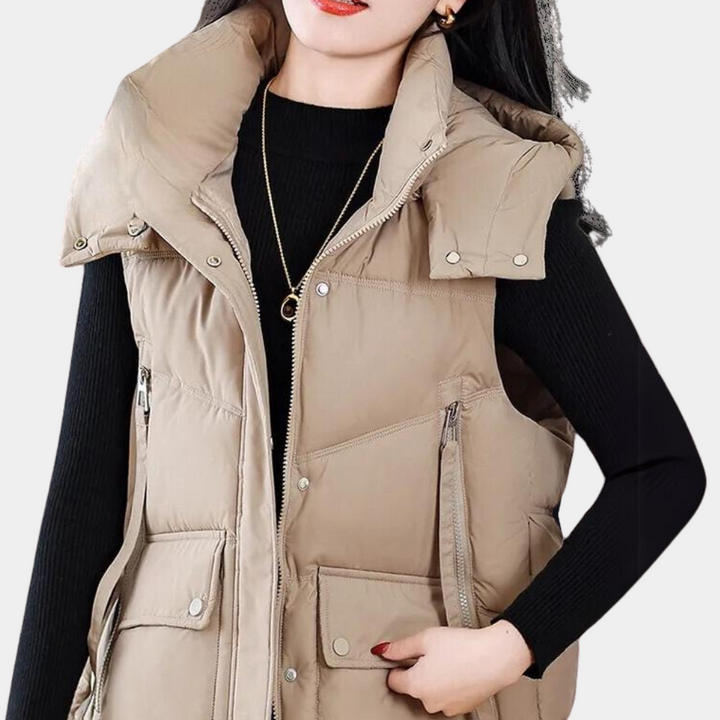 Dames beige gewatteerde bodywarmer, modieuze winterjas met hoge kraag en zakken, ideaal voor casual en outdoor activiteiten.