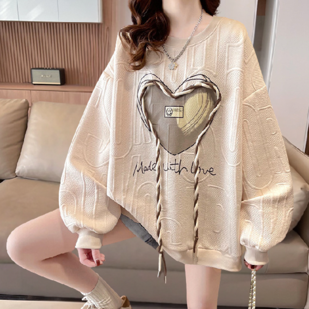 Damestrui met hartprint en tekst "Made with Love", oversized pasvorm, beige kleur, trendy mode, comfortabele casual stijl, perfect voor herfst.