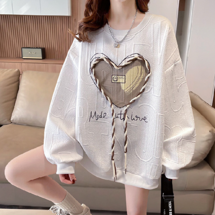 Witte oversized trui met hartvormig patroon en tekst "Made with Love", trendy damesmode, comfortabele casual outfit, perfect voor herfst en winter.