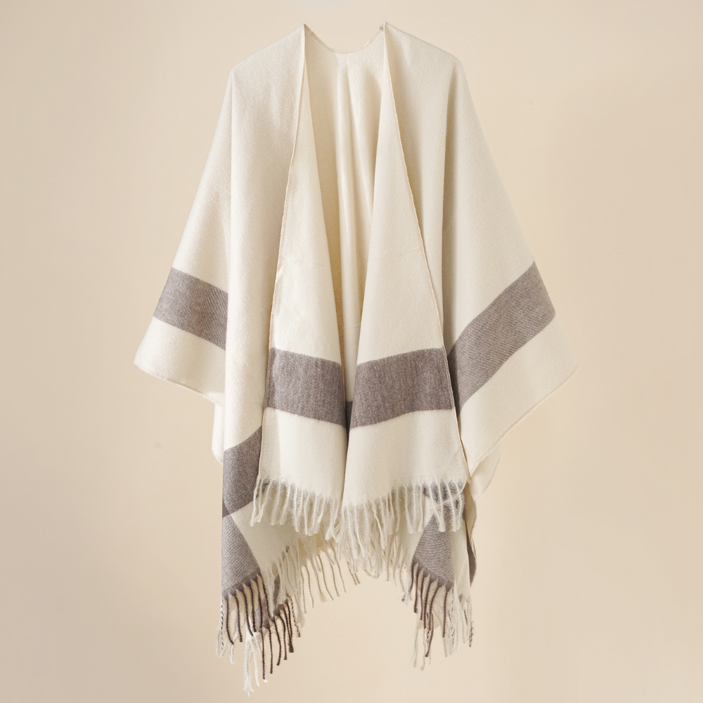 Beige poncho met grijze strepen en franjes, handgemaakt van wol. Stijlvolle en warme omslagdoek voor dames. Perfect voor herfst- en wintermode.