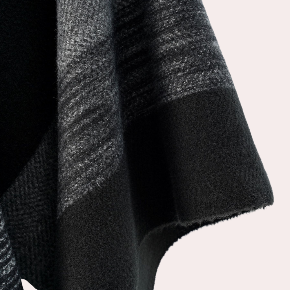 Grijze wollen sjaal met zwart-wit geruit patroon, zachte textuur en elegante afwerking. Perfect voor wintermode en stijlvolle accessoires.