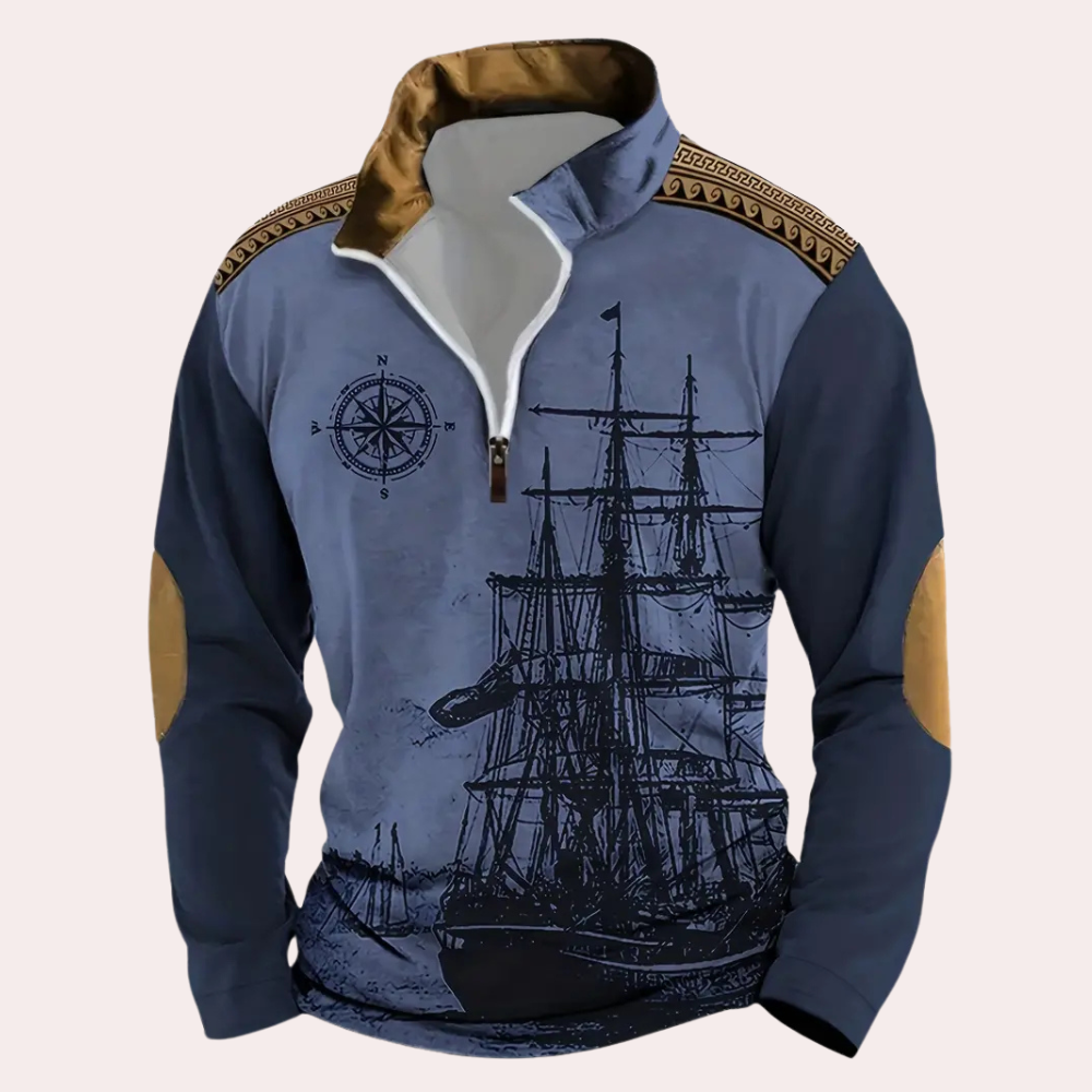 Blauwe nautische trui met kompas en schip print, bruine schouderdetails en elleboogstukken. Perfect voor maritieme mode en casual stijl.