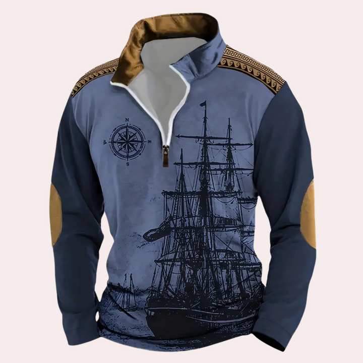 Blauwe nautische trui met kompas en schip print, bruine schouderdetails en elleboogstukken. Perfect voor maritieme mode en casual stijl.