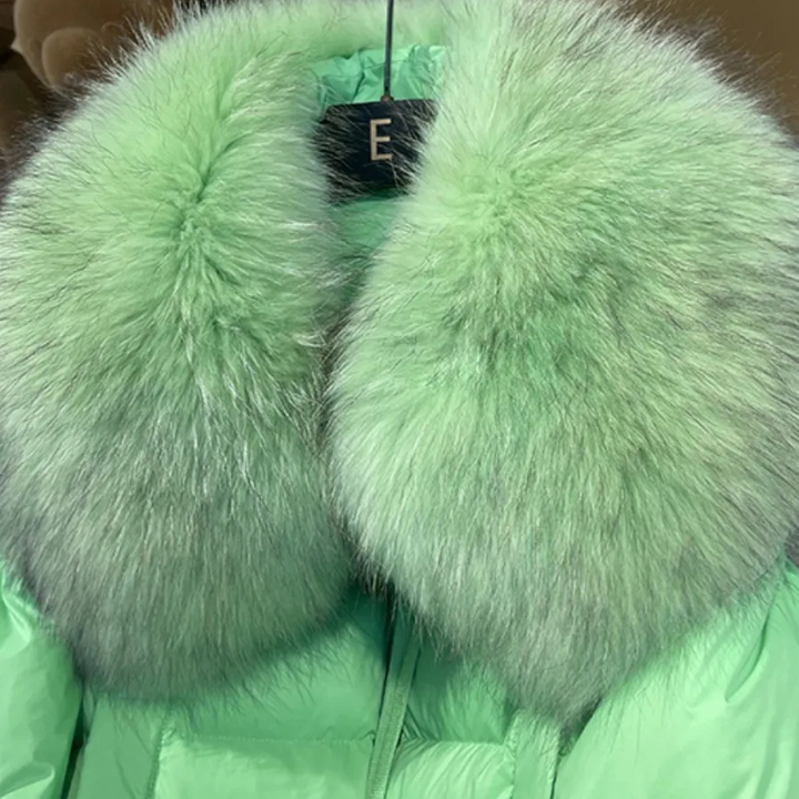 Mintgroene winterjas met grote, pluizige bontkraag, stijlvolle damesmode, warme winterkleding, luxe uitstraling, trendy design.