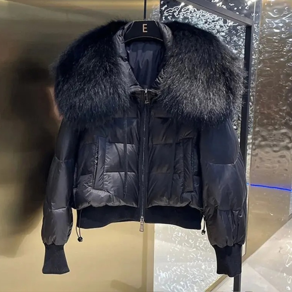 Zwarte gewatteerde jas met grote bontkraag, luxe wintermode, stijlvolle damesjas, warme en modieuze kleding, trendy design.
