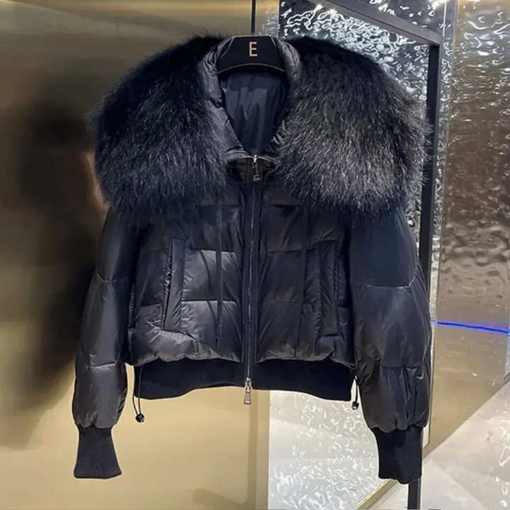 Zwarte gewatteerde jas met grote bontkraag, luxe wintermode, stijlvolle damesjas, warme en modieuze kleding, trendy design.