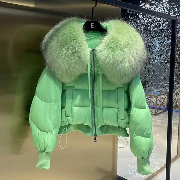 Lichtgroene gewatteerde jas met grote bontkraag, hangend aan een hanger. Modieuze winterjas, trendy dameskleding, luxe uitstraling.
