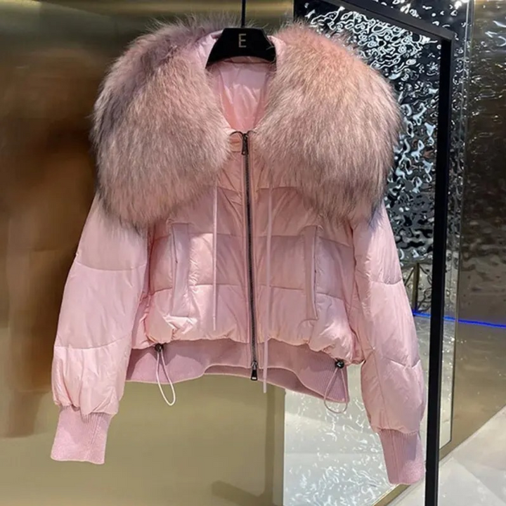 Lichtroze gewatteerde jas met grote bontkraag, trendy wintermode, dameskleding, stijlvolle warme jas, luxe uitstraling, modieuze buitenkleding.