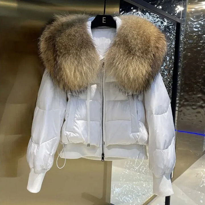 Witte gewatteerde jas met bruine bontkraag, luxe wintermode, stijlvolle damesjas, warme kleding, modetrend, hoogwaardige materialen.