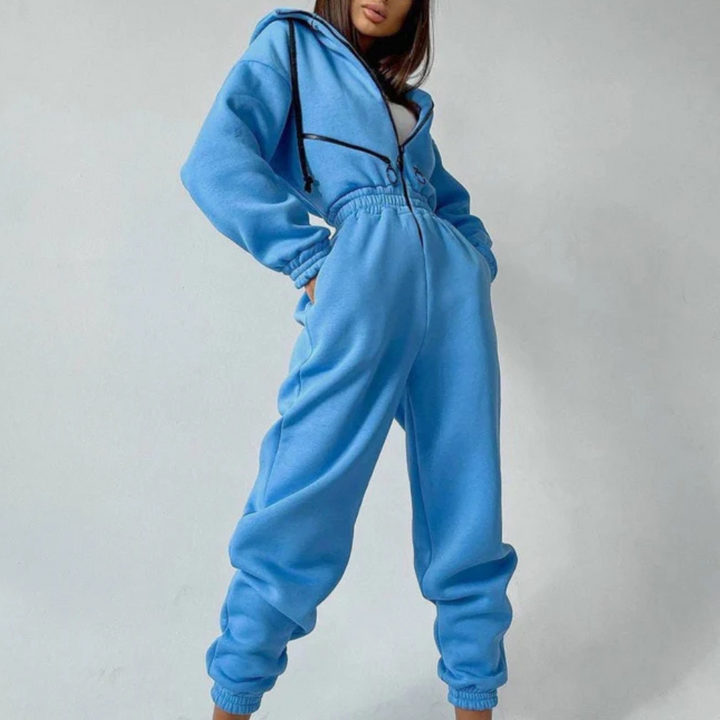 Blauwe damesjumpsuit met capuchon, comfortabele pasvorm, trendy streetwear, casual mode, perfect voor dagelijks gebruik en sportieve stijl.