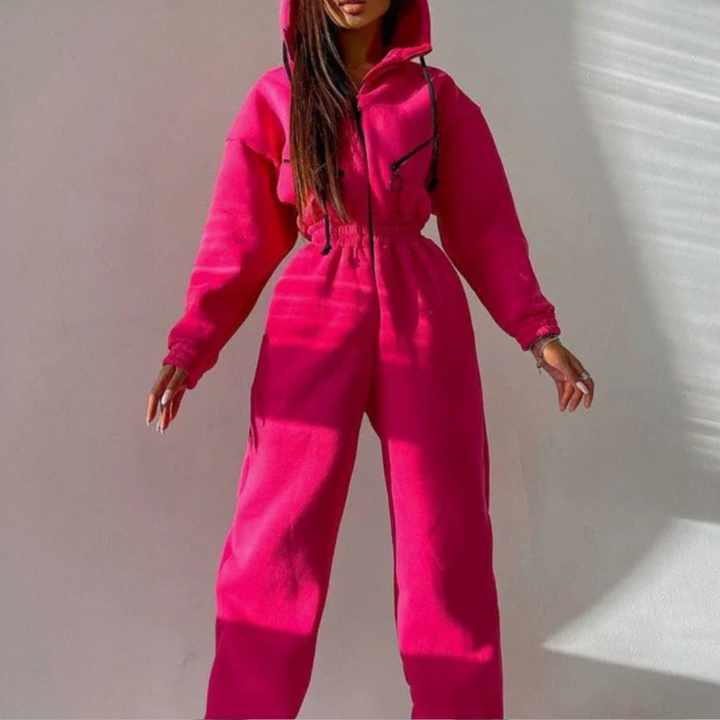 Vrouw in felroze joggingpak met capuchon, trendy streetwear, comfortabele mode, casual outfit, sportieve stijl, herfstkleding.