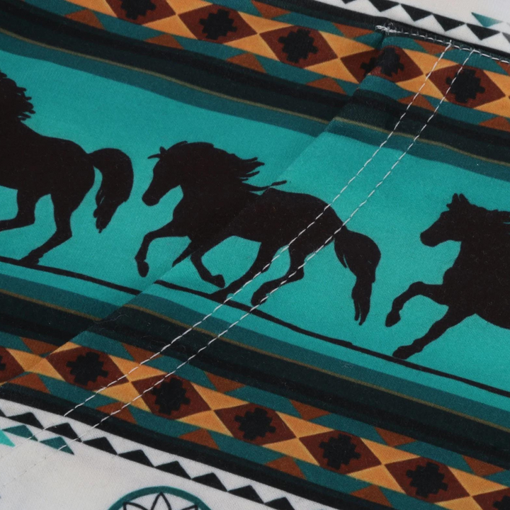 Close-up van kleurrijke stof met silhouetten van galopperende paarden en geometrische patronen. Ideaal voor paardendecoratie en textielontwerp.