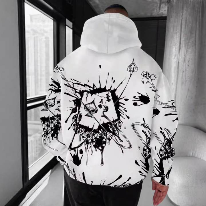 Man in witte hoodie met zwart-wit speelkaartontwerp, abstracte kunststijl, in moderne kamer. Trendy streetwear mode, unisex kleding.