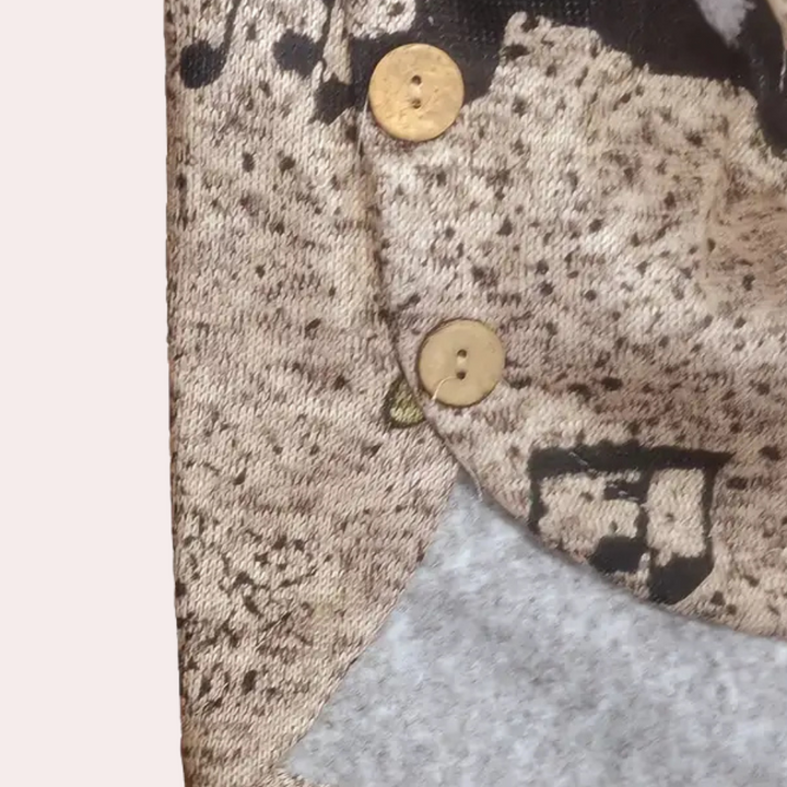 Close-up van een beige wollen jas met bruine knopen en zwart-wit patroon. Modieuze winterkleding, warme stof, stijlvolle knoopdetails.