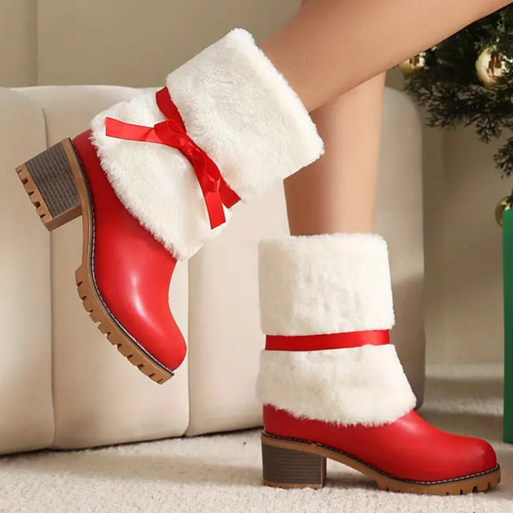 Rode dameslaarzen met witte bontkraag en hak, versierd met rode strik, perfect voor kerstoutfits. Modieuze winterlaarzen voor dames.