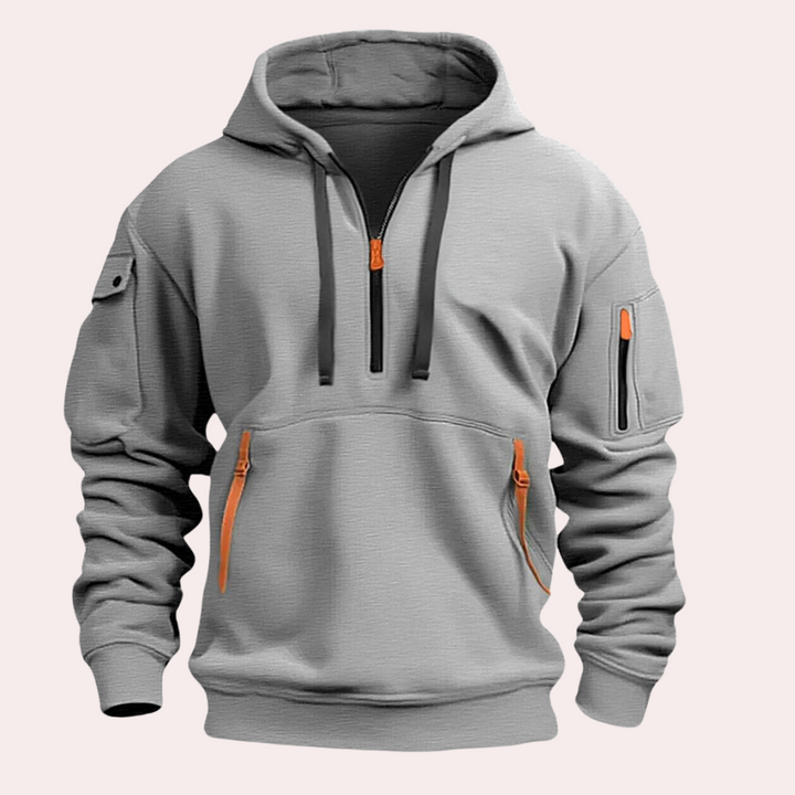 Grijze herenhoodie met oranje ritsen, zakken op mouw en buik, comfortabele pasvorm, casual streetwear, modieuze herenkleding.