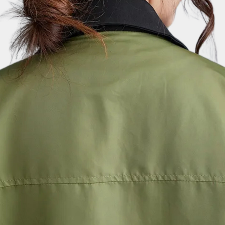Groene jas met zwarte kraag, close-up van de achterkant. Modieuze dameskleding, herfstjas, casual stijl, hoogwaardige stof.