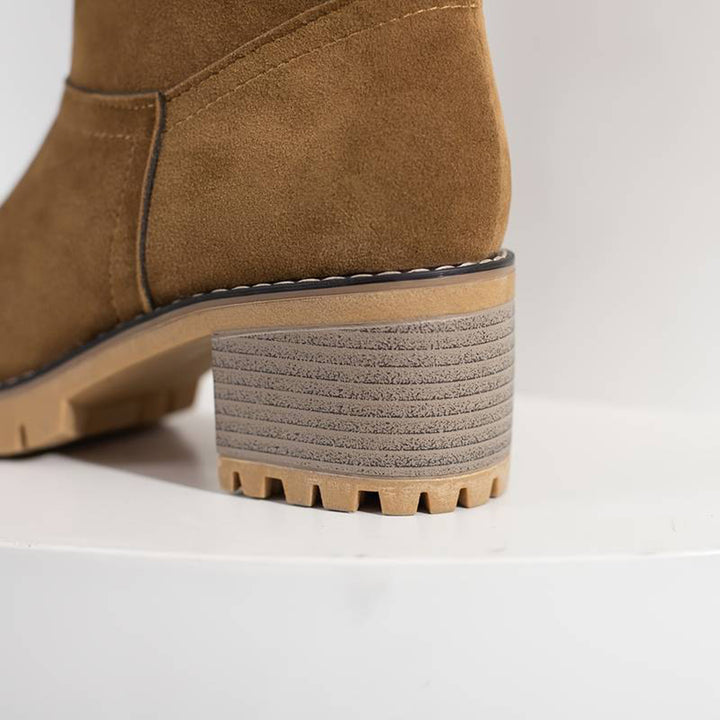 Bruine suède enkellaars met blokhak en geribbelde zool, stijlvolle damesmode, herfst- en wintercollectie, comfortabele en trendy schoenen.