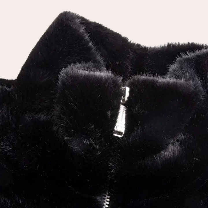 Zwarte faux bontjas met ritssluiting, zachte textuur, modieuze winterkleding, warme damesjas, trendy en stijlvol design.