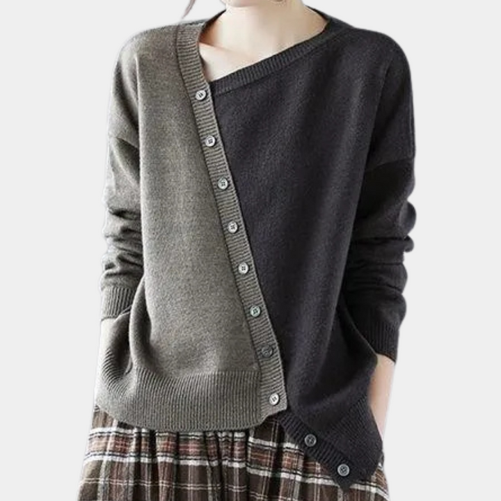Grijze en olijfgroene asymmetrische damestrui met knopen, gecombineerd met geruite rok. Modieuze herfstkleding, trendy damesmode.