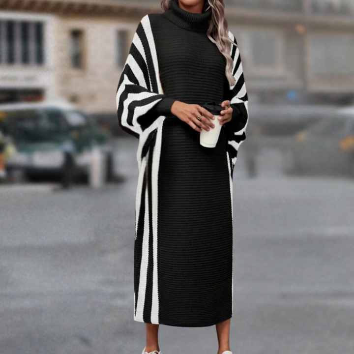 Zwart-witte gestreepte maxi-jurk met coltrui, gedragen door vrouw op straat. Modieuze winterkleding, comfortabele en stijlvolle outfit.