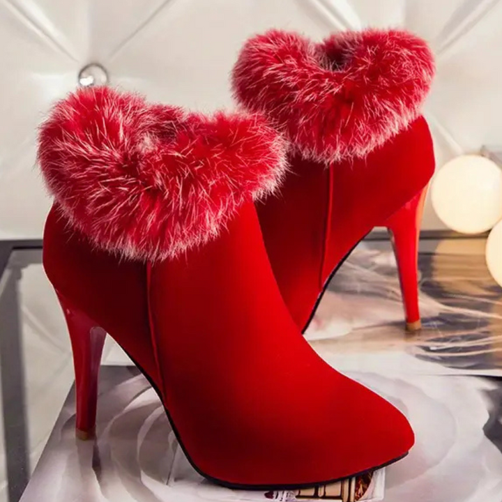 Rode dameslaarzen met hoge hakken en pluizige bontkraag, modieuze winterlaarzen, elegante schoenen voor feestjes en speciale gelegenheden.
