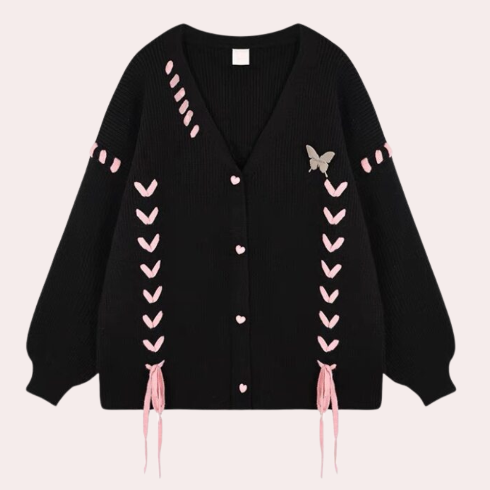Zwarte gebreide cardigan met roze hartvormige knopen, vlinderdetail en decoratieve roze stiksels. Trendy damesmode, herfstkleding, casual stijl.