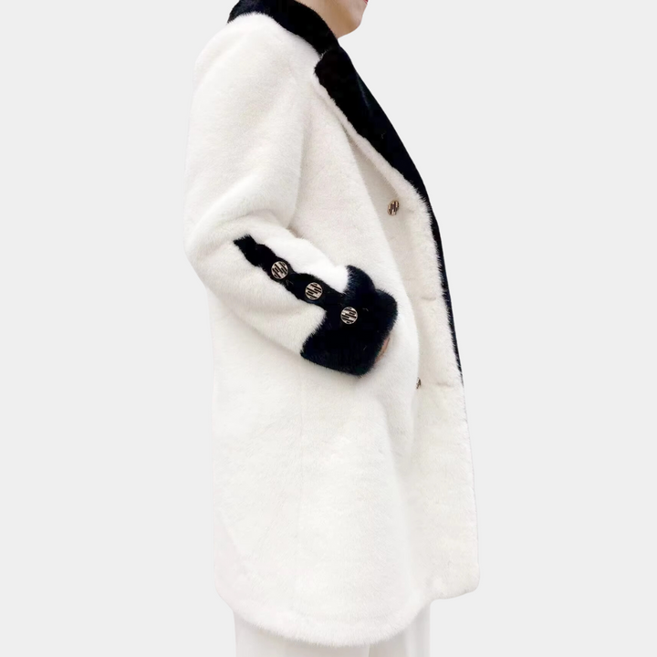 Witte damesjas met zwarte kraag en manchetten, knopen aan de voorkant, elegante wintermode, luxe design, warme kleding, stijlvolle uitstraling.