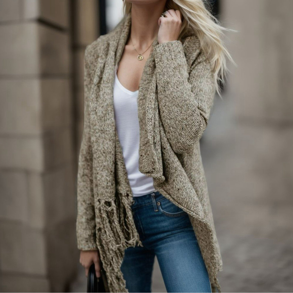 Vrouw in casual herfstoutfit met beige gebreid vest, witte top en blauwe jeans. Modieuze kleding, herfstmode, dameskleding, straatstijl.