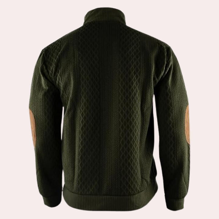 Donkergroene herensweater met kabelpatroon en bruine elleboogstukken, comfortabele pasvorm, ideaal voor herfst en wintermode.