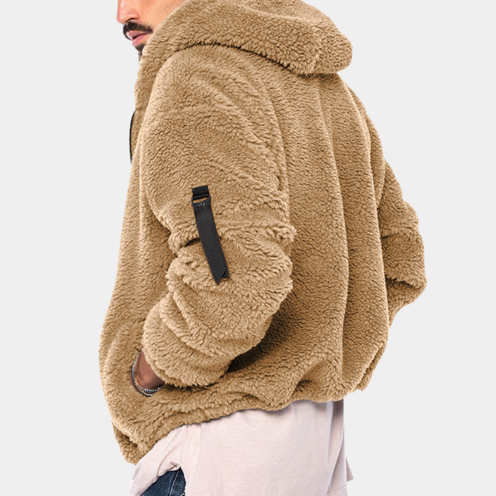 Man in warme, bruine teddyfleece hoodie met capuchon en zak op mouw. Stijlvolle herenkleding, comfortabele wintertrui.