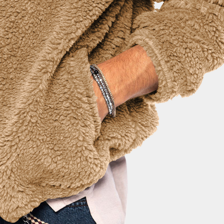 Man in warme, bruine teddy trui met capuchon, draagt zilveren armband. Modieuze herenkleding, comfortabele winterstijl, casual outfit.
