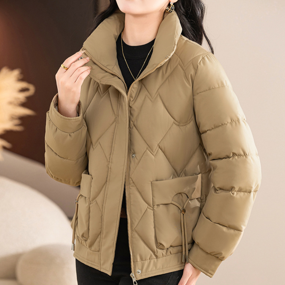 Vrouw draagt beige gewatteerde winterjas met rits en zakken, modieuze dameskleding, warme jas voor koude seizoenen, stijlvolle winteroutfit.