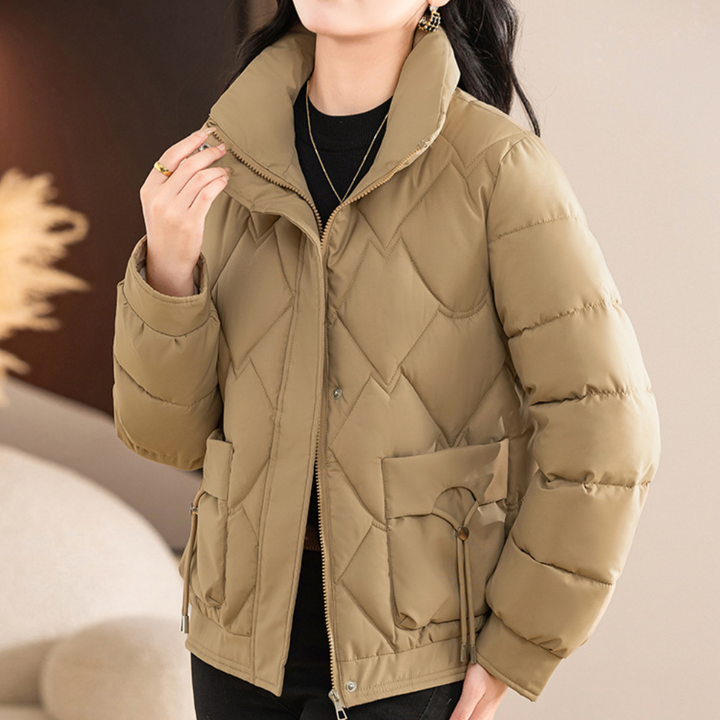 Vrouw draagt beige gewatteerde winterjas met rits en zakken, modieuze dameskleding, warme jas voor koude seizoenen, stijlvolle winteroutfit.