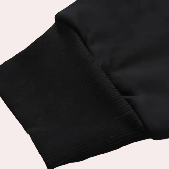 Zwarte mouw van een hoodie met geribde boorden, detailopname. Comfortabele streetwear, casual mode, unisex kleding.
